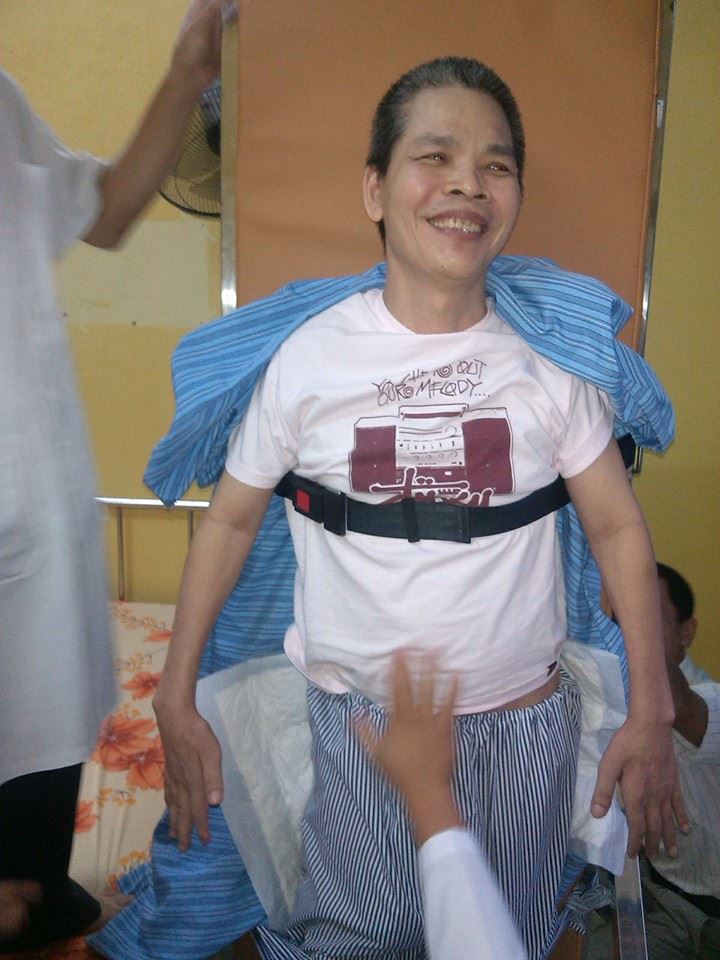 Giúp bệnh nhân liệt do tổn thương tủy sống tập đứng bằng bàn nghiêng.